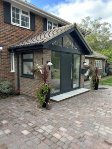 Dark grey aluminium front door with sidelights, different house