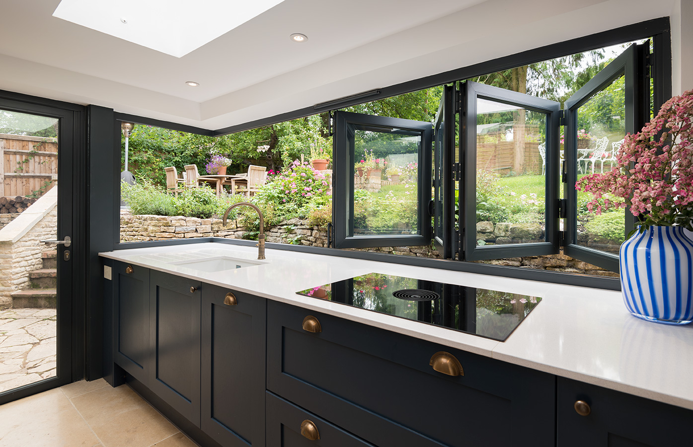 Bi-fold window open over sink looking to garden