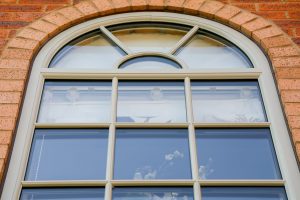 Close-up of an arched casement window with Georgian bar