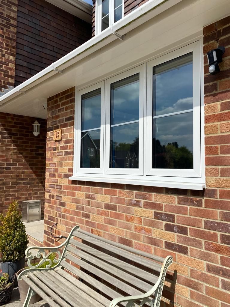 Three-light casement window on red brick