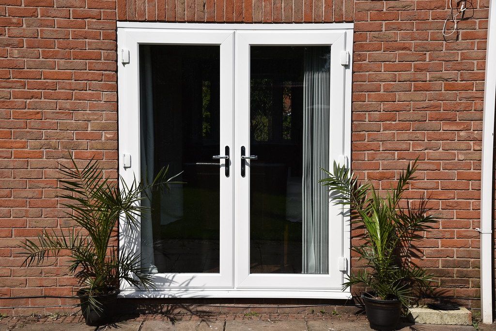 White uPVC French doors, brick house