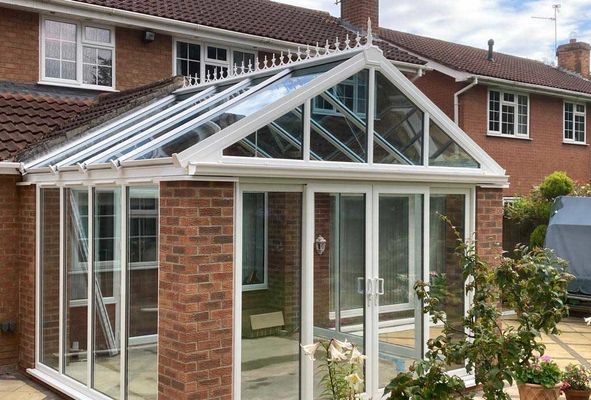 White uPVC gable-end conservatory, red brick house