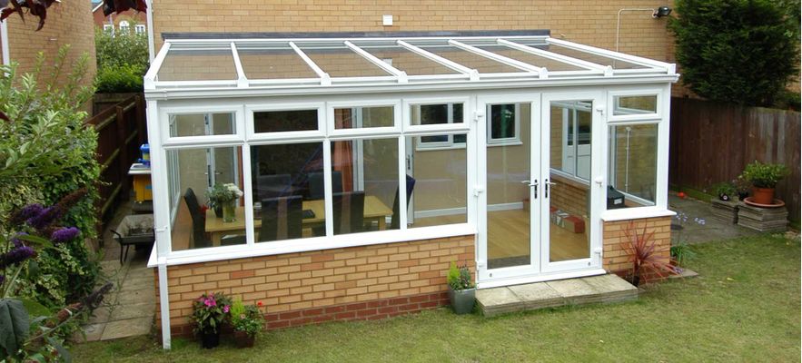 White lean-to conservatory, garden view