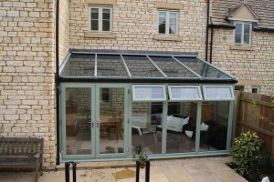 Sage green lean-to conservatory, stone house