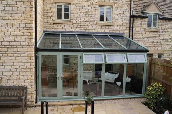 Sage green lean-to conservatory, stone house
