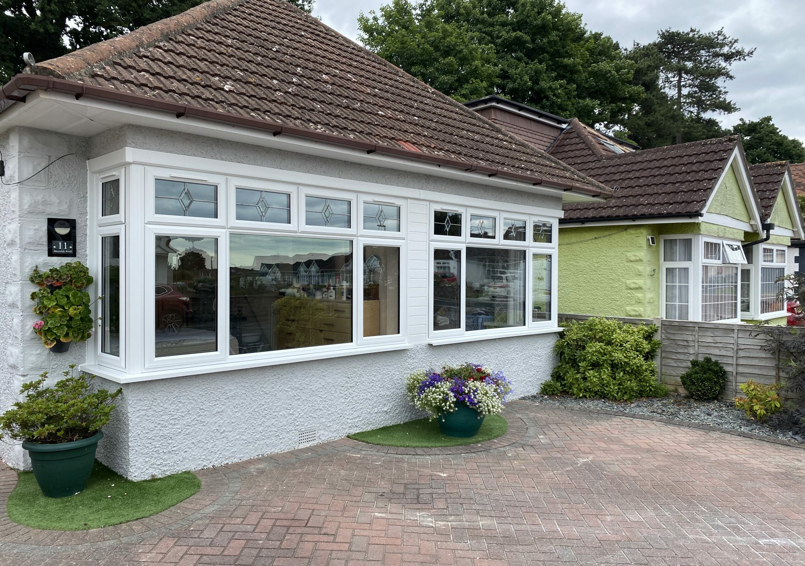 White uPVC bay window installation on a red-brick bungalow